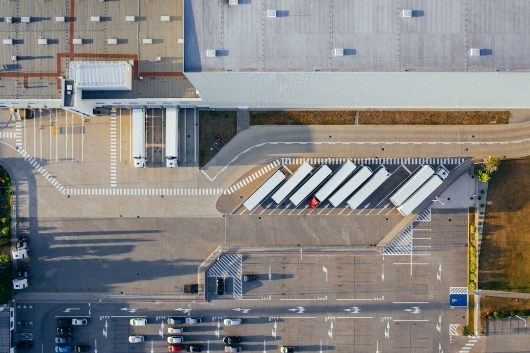Et logistikkbygg sett ovenfra med lastebiler parkert utenfor.